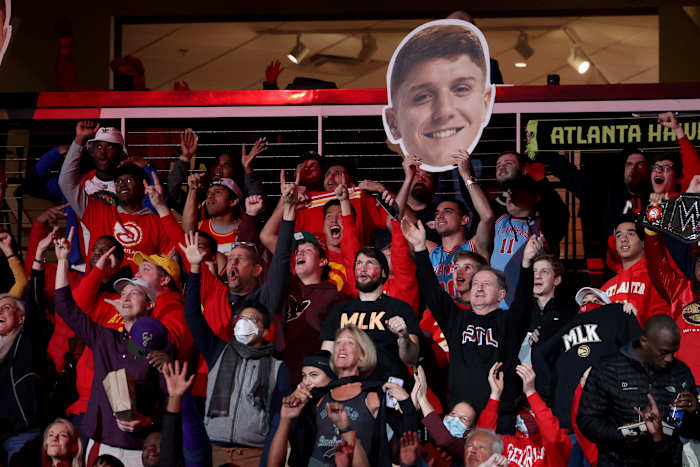 Jan 17, 2022; Atlanta, Georgia, USA; Atlanta Hawks fans cheer as they hold an image of Atlanta Hawks guard Kevin Huerter during the second half against the Milwaukee Bucks at State Farm Arena.